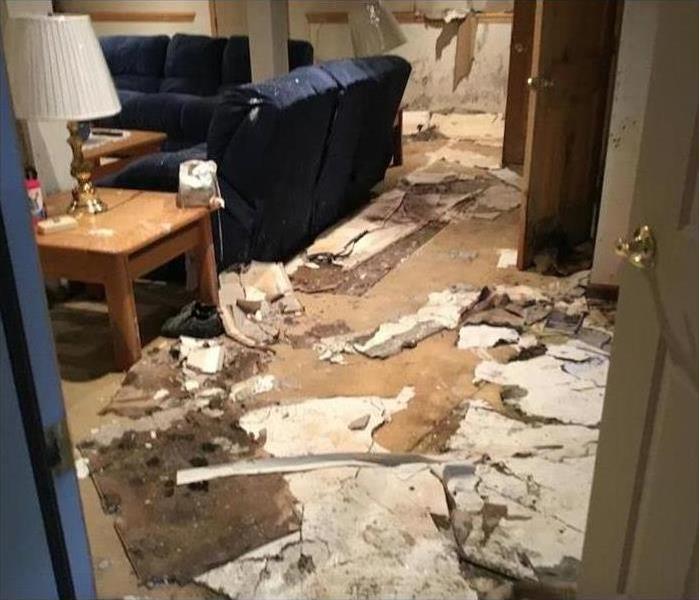 A family room floor covered in a mess of materials after a storm blew through
